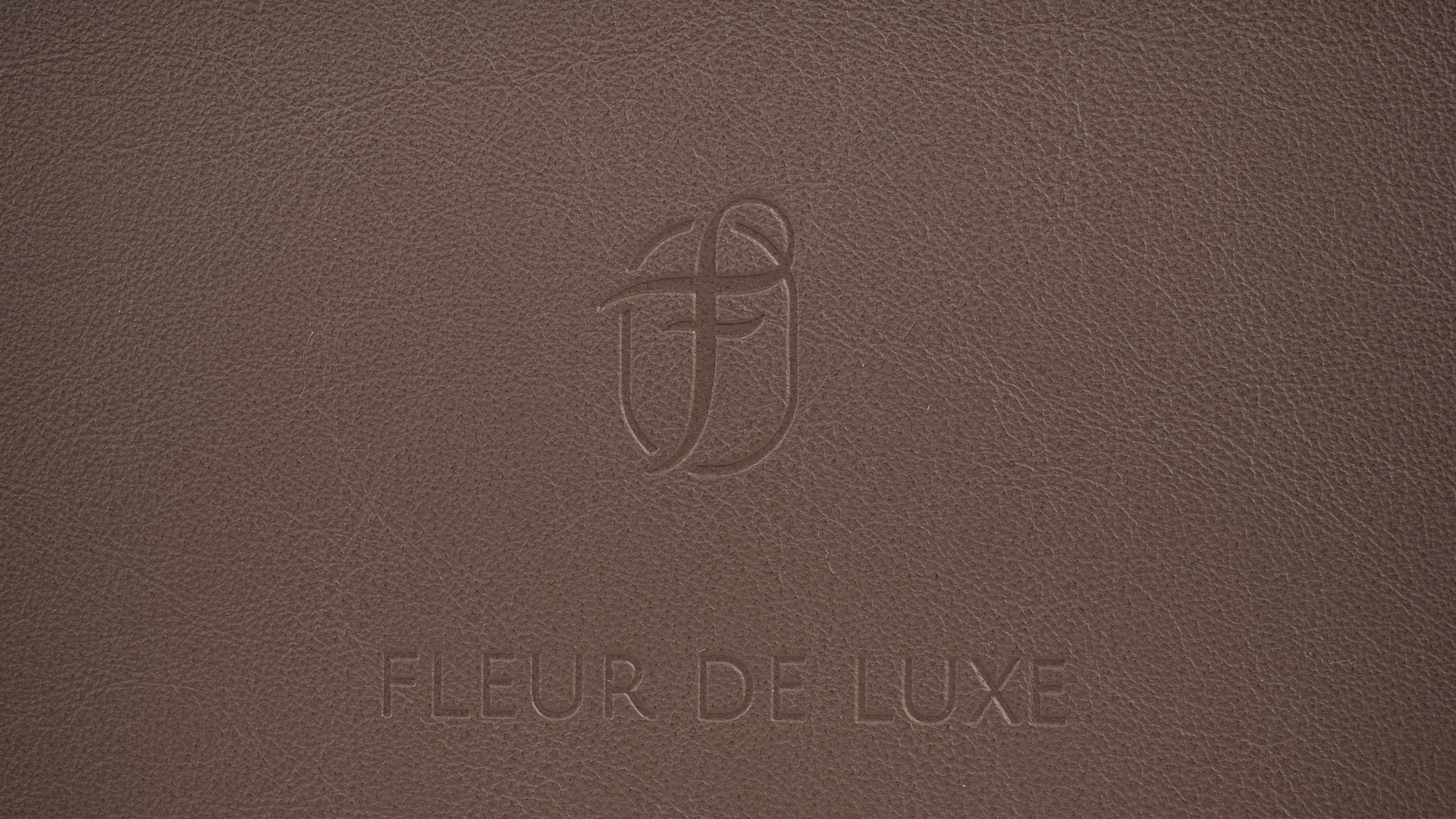 Nahaufnahme der Fleur de Luxe Prägung auf dem Kalbsleder in der Farbe Terra.