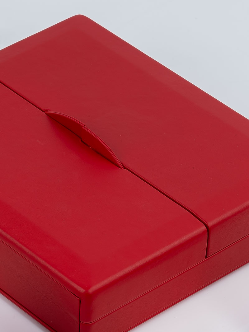 Detail of a Fleur de Luxe necklace case red closed with central lid opening and grip tabs